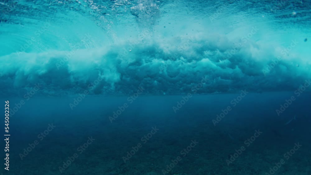 Clear ocean wave breaks on the shore with splashes. Wave rolls and breaks in the Maldives
