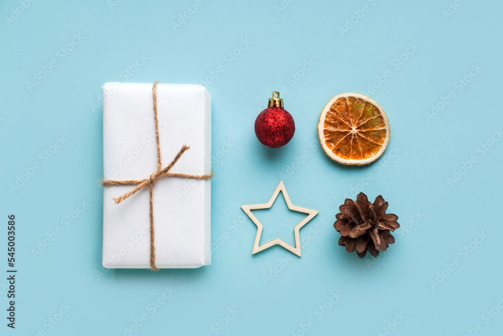 Winter zero waste set composition, trendy eco green red craft gift, christmas cone, tree branch, star, dried orange on blue background. Front view, flat lay, mock up, isolated. Greeting minimal card Winter zero waste set composition, trendy eco green red craft gift, christmas cone, tree branch, star, dried orange on blue background. Front view, flat lay, mock up, isolated. Greeting minimal card