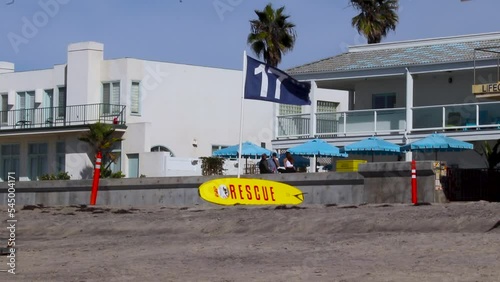 Yellow Lifeguard rescue board leaning against flag 17 at Delmar beach photo