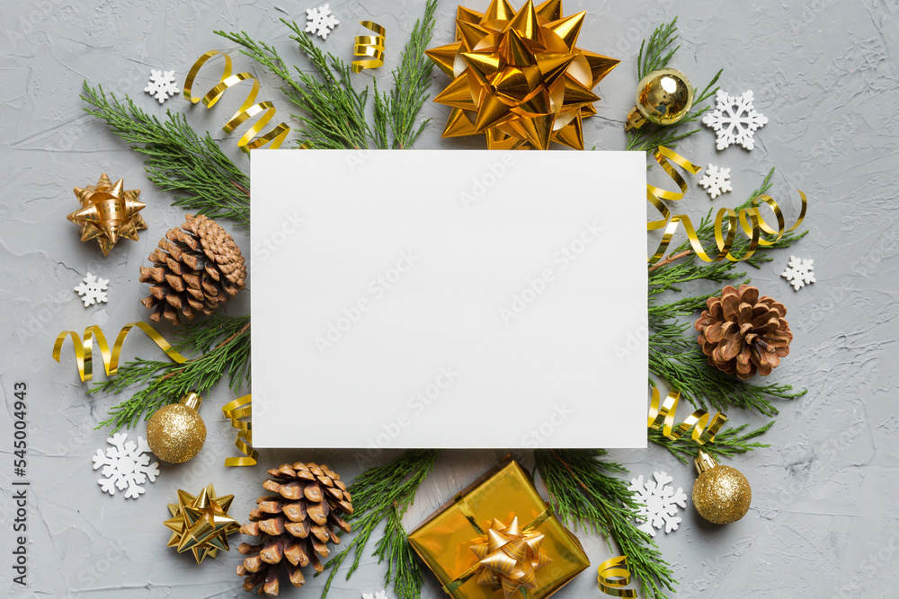 Fototapeta premium Flat lay Christmas composition. square Paper blank, pine tree branches, christmas decorations on Colored background. Top view, copy space for text