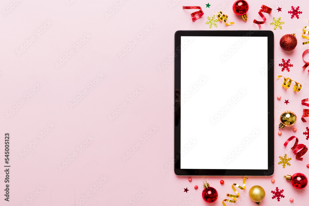 Christmas online shopping from home tablet pc with blank white display top view. Tablet with copy space on colored background with Christmas decorations balls,. Winter holidays sales background Christmas online shopping from home tablet pc with blank white display top view. Tablet with copy space on colored background with Christmas decorations balls,. Winter holidays sales background