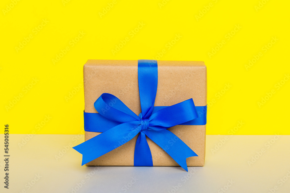 holiday handmade paper present tied blue ribbon bow top view with copy space. Flat lay holiday background. Birthday or christmas present. Christmas gift box concept with copy space holiday handmade paper present tied blue ribbon bow top view with copy space. Flat lay holiday background. Birthday or christmas present. Christmas gift box concept with copy space