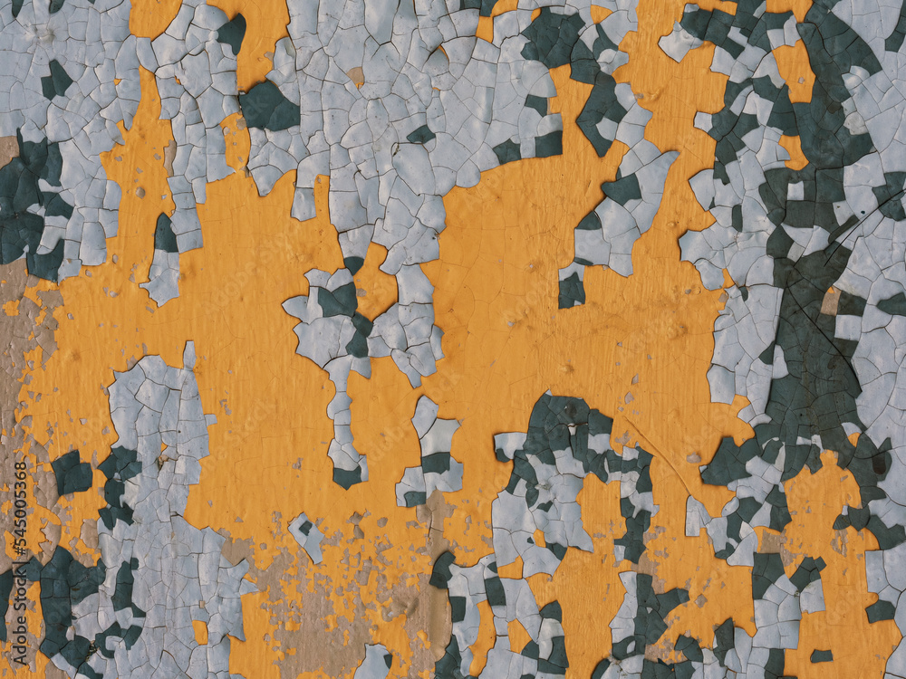 Peeling paint on the wall. Old concrete wall with cracked flaking paint. Weathered rough painted surface with patterns of cracks and peeling. Grunge texture for background and design. Closeup
