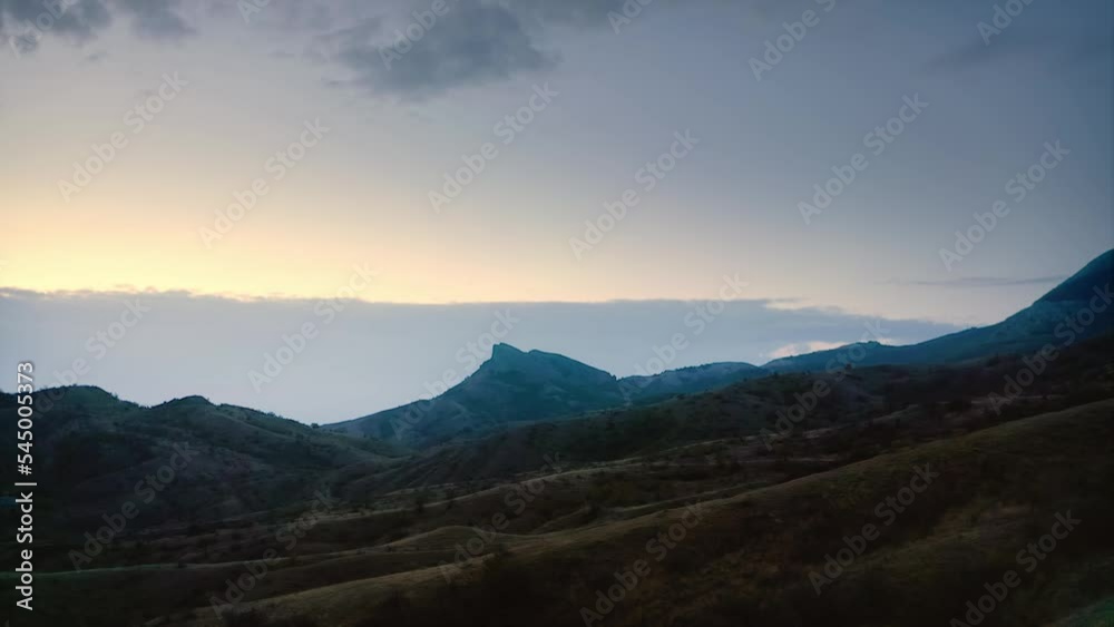 Dawn on the steppe over yellow, tall grass with a lonely mountain as a backdrop. Drone aerial shot. Dawn on the steppe over yellow, tall grass with a lonely mountain as a backdrop. Drone aerial shot.