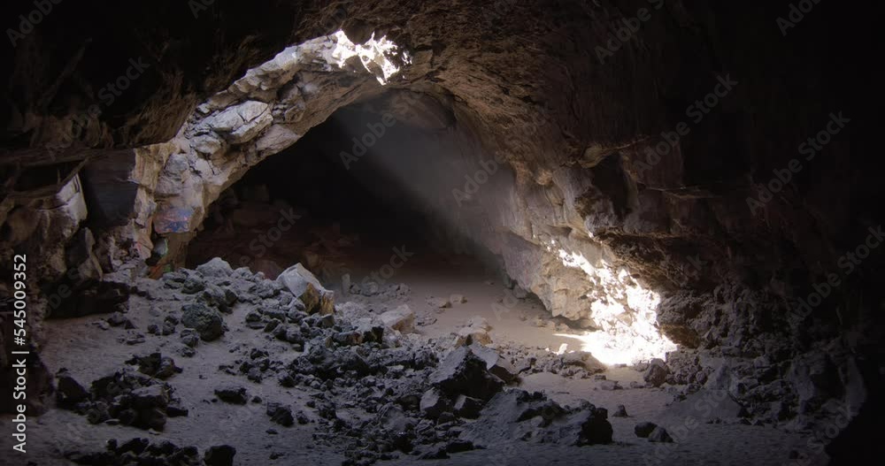 Dust swirls in Ray of light shining down from ceiling of collapsing cave