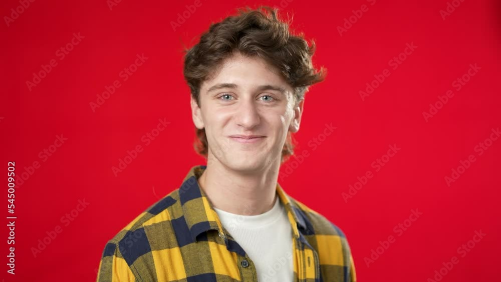 Portrait of smiling happy young hipster rman 20s isolated on solid red background with copy space in studio Portrait of smiling happy young hipster rman 20s isolated on solid red background with copy space in studio