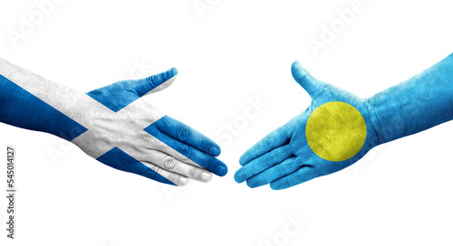 Handshake between Palau and Scotland flags painted on hands, isolated transparent image.