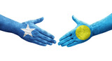 Handshake between Palau and Somalia flags painted on hands, isolated transparent image.