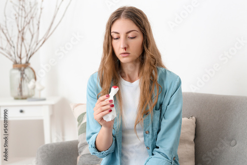 Young woman with nosebleed ...