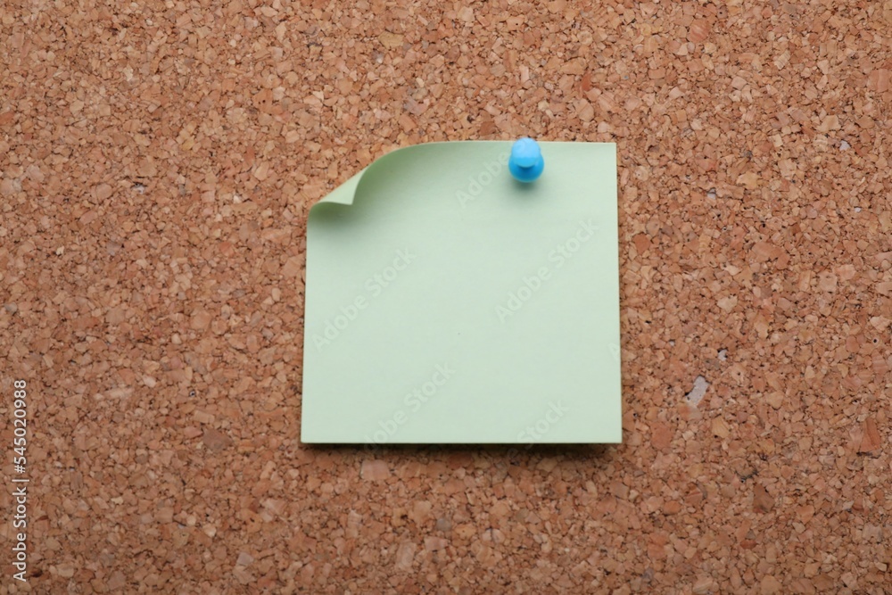Blank paper note pinned to cork background, closeup Blank paper note pinned to cork background, closeup