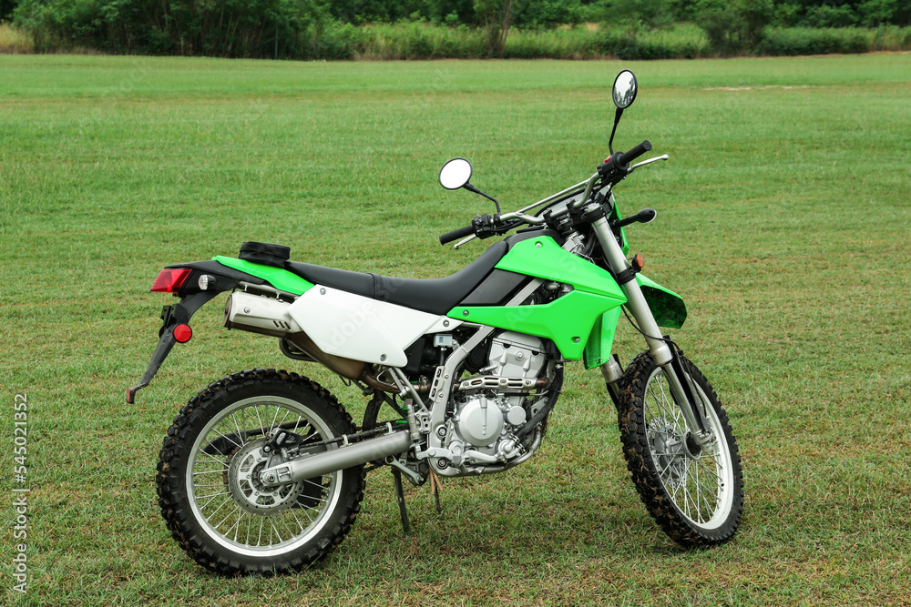 Stylish cross motorcycle on green grass outdoors Stylish cross motorcycle on green grass outdoors