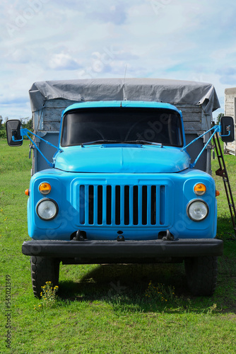 Light blue old truck on green lawn with fresh grass