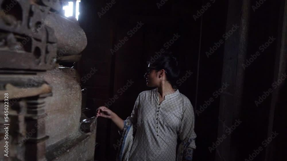 A Female Visitor Looking At The Interior Wall Sculptures While Walking Around Inside Khajuraho Temple In Madhya Pradesh, India. - Slow Motion A Female Visitor Looking At The Interior Wall Sculptures While Walking Around Inside Khajuraho Temple In Madhya Pradesh, India. - Slow Motion