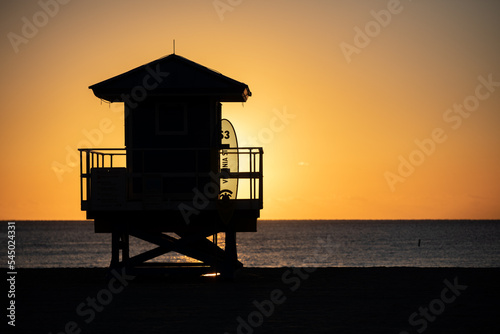 Life Guard tower is silhouetted against a colorful sunrise on Hollywood Beach, Florida