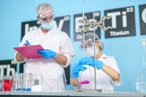 Modern medical research laboratories Beautiful female scientist wearing protective goggles mixes chemicals in test tubes in laboratory biochemical samples, an advanced science laboratory for medicine.