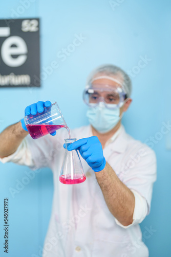 Modern medical research laboratories Beautiful male scientist wearing protective goggles mixes chemicals in test tubes in laboratory biochemical samples, an advanced science laboratory for medicine.