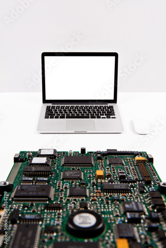 Laptop and circuit board isolated from background. You can change the background freely. communication network. silver metal surface. digital modern communication computer technology