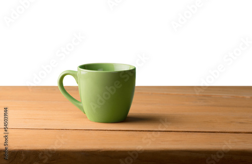 Green cup of coffee on wooden table in office