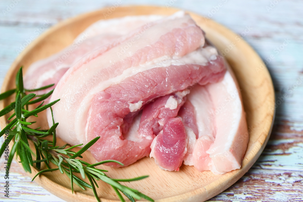 fresh raw streaky pork meat for cooking food, pork skin pig skin, pork on wooden plate with rosemary fresh raw streaky pork meat for cooking food, pork skin pig skin, pork on wooden plate with rosemary