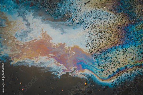 A puddle of spilled oil product on the road. Environmental pollution concept