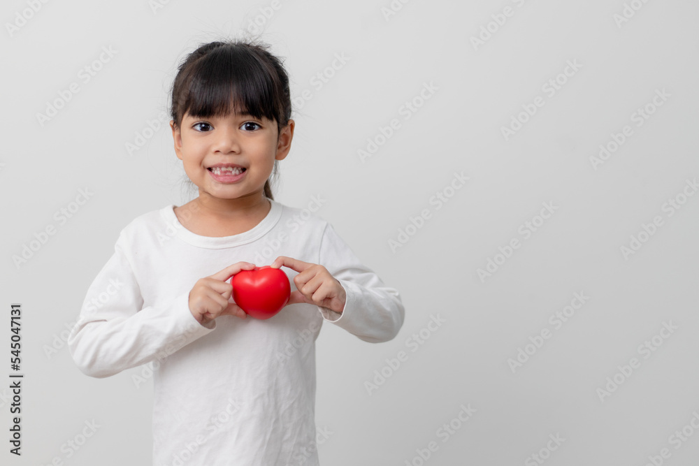 Portrait of Asian little girl child holding red heart sign on white background Portrait of Asian little girl child holding red heart sign on white background