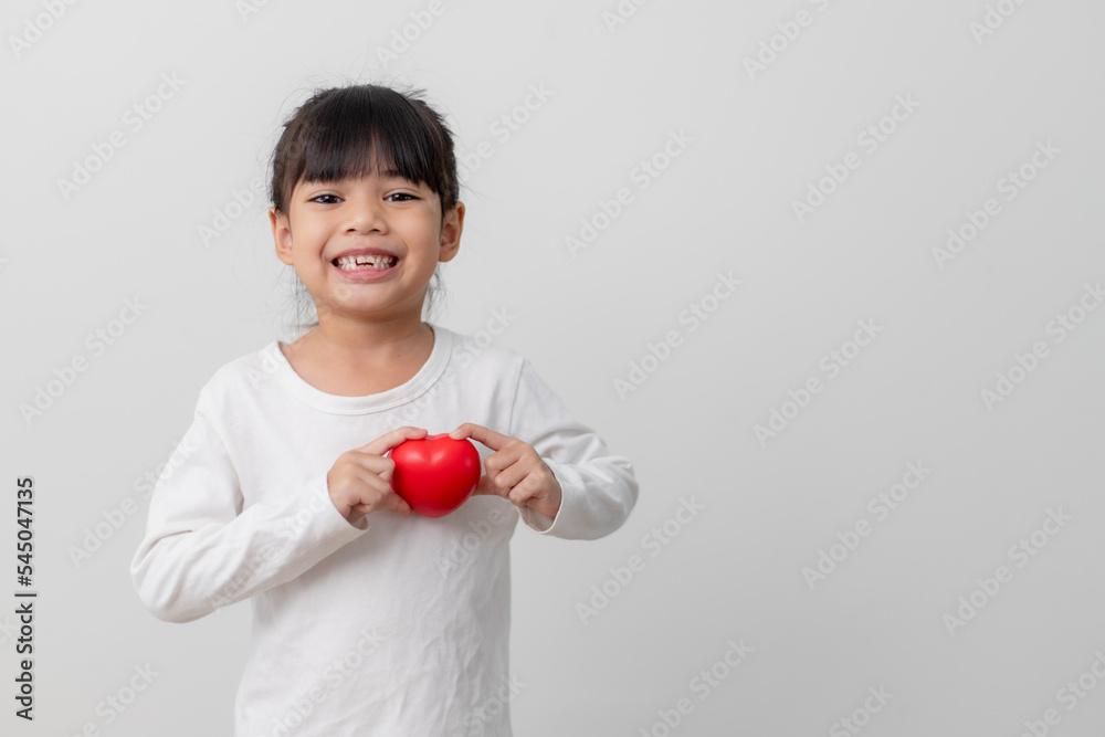 Portrait of Asian little girl child holding red heart sign on white background Portrait of Asian little girl child holding red heart sign on white background
