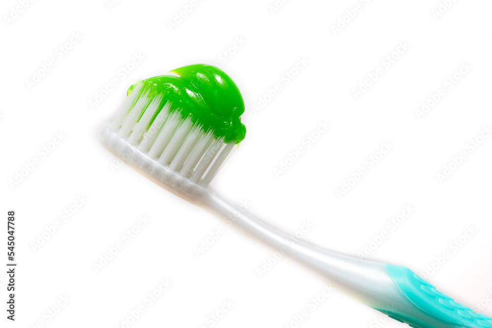 A toothbrush in close-up, on which green toothpaste was squeezed out A toothbrush in close-up, on which green toothpaste was squeezed out