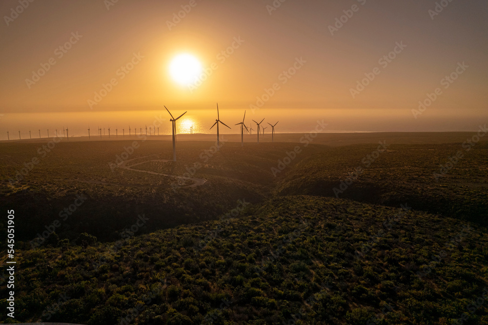Obraz premium atardecer en un parque eólico en el desierto de atacama a la orilla del mar