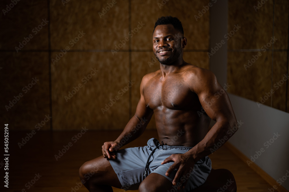 Handsome afro american shirtless man posing in the gym. 