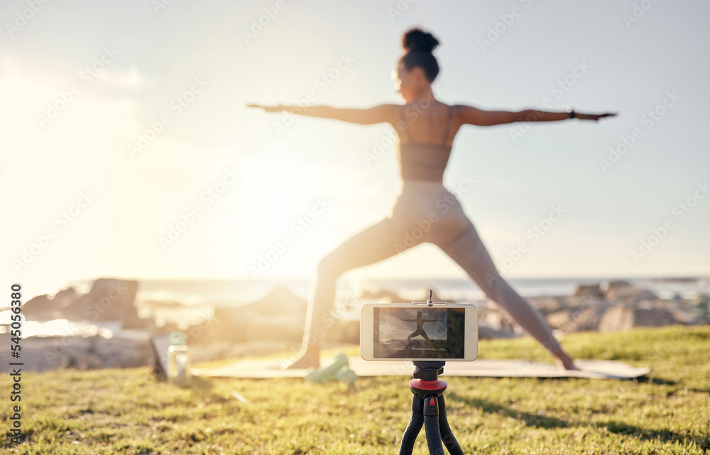 Yoga, fitness and live streaming woman smartphone in nature for social media, influencer blog or wellness content creation. Stretching, pilates and fitness content creator girl with videography app
