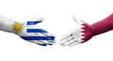 Handshake between Qatar and Uruguay flags painted on hands, isolated transparent image.