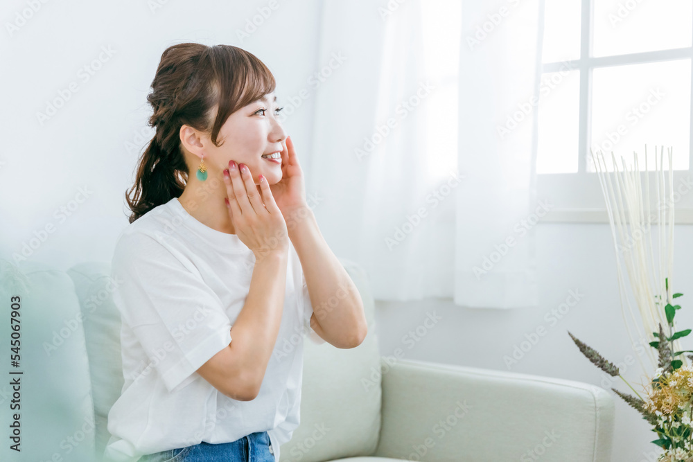 ソファに座りながら化粧品・コスメで保湿する日本人女性
ソファに座りながら化粧品・コスメで保湿する日本人女性