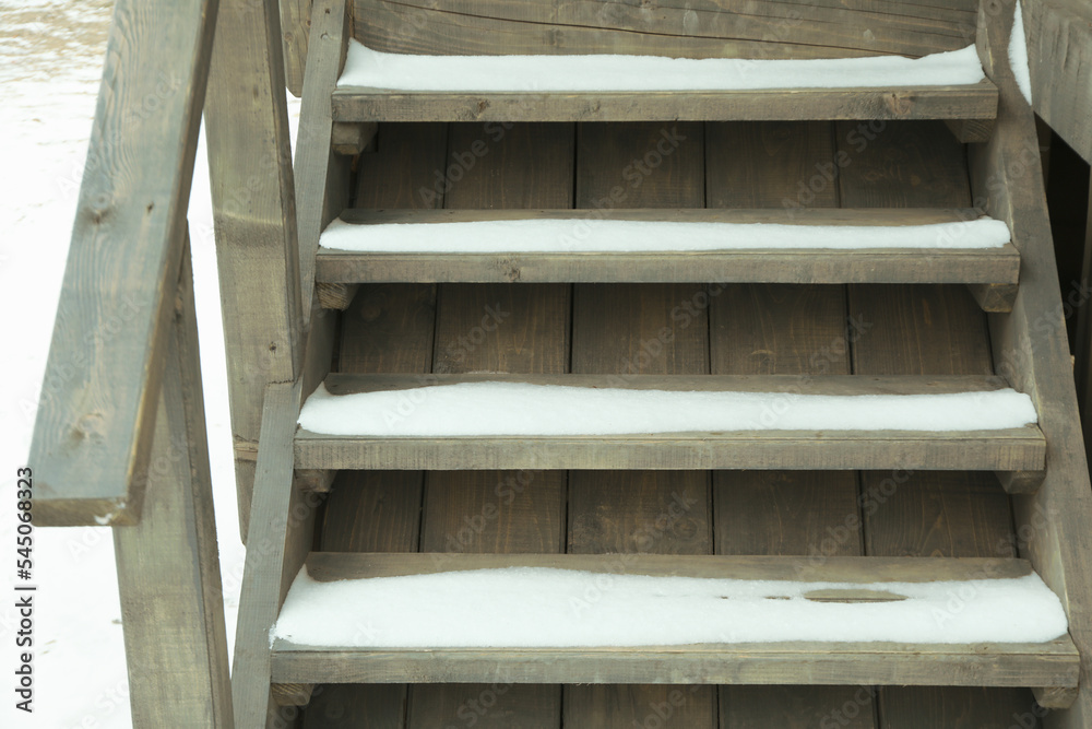 Wooden steps with snow of cozy wooden house outdoor Wooden steps with snow of cozy wooden house outdoor