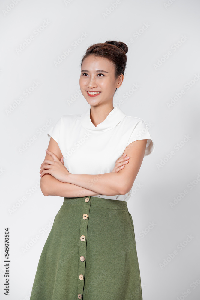 Φωτογραφία Portrait of a young asian woman with a pleasant smile and crossed arms isolated