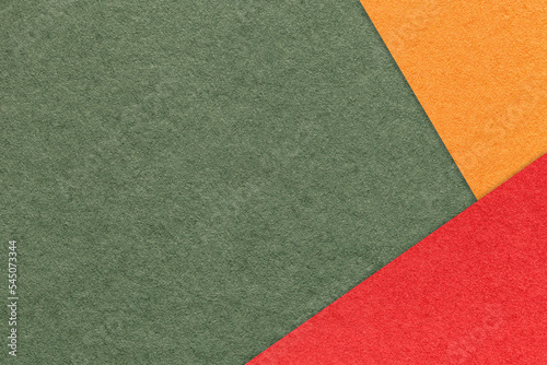 Craft dark olive color paper background with red and orange border. Vintage green cardboard. Presentation template