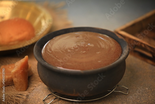 ragi malt, finger millet porridge served in a traditional mud pot served closeup with selective focus and blur