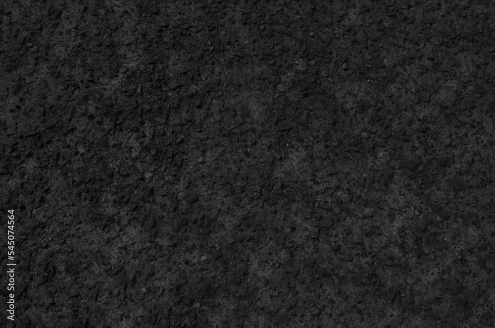 Fototapeta premium Black washed out earthen floor texture background. Pebble-filled road surface.