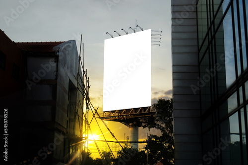 Portrait billboard white blank for outdoor advertising at sunset city background.