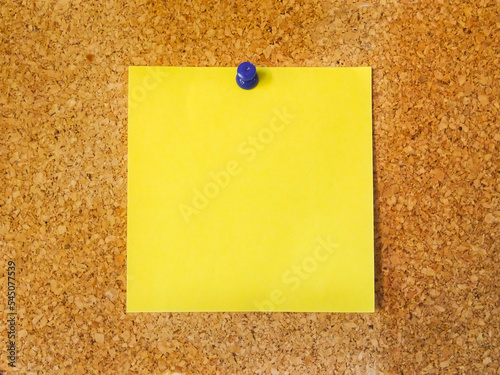 Yellow adhesive note pinned on a cork board.  Blank space to write down reminder