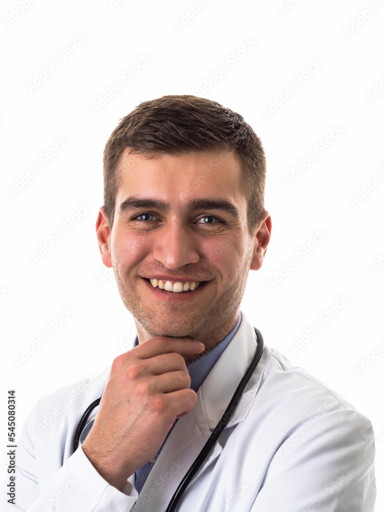 Portrait of hero in white coat. Cheerful smiling young doctor with stethoscope in medical hospital standing against white background. Coronavirus covid-19 danger alert Portrait of hero in white coat. Cheerful smiling young doctor with stethoscope in medical hospital standing against white background. Coronavirus covid-19 danger alert