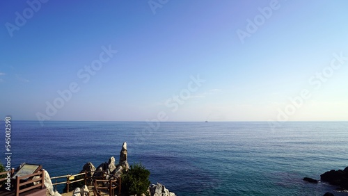 a cliff with strange rocks and a view of the blue sea
