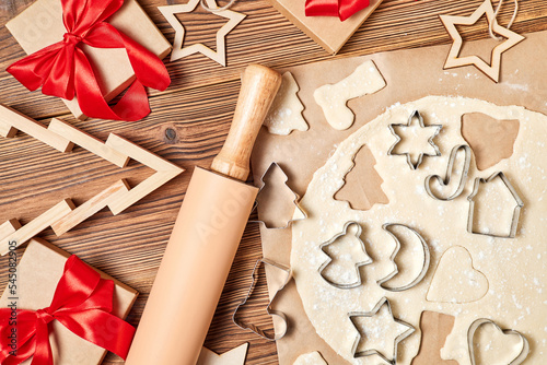 Fototapeta Naklejka Na Ścianę i Meble -  Making gingerbread Christmas Cookies Using form for cooking on wooden background