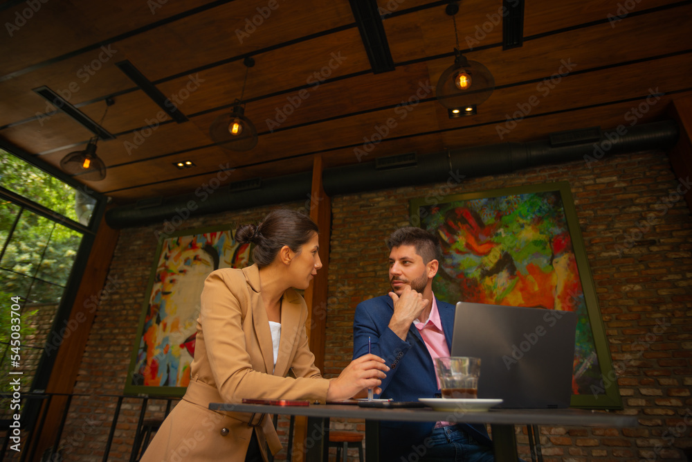 Two young business people are enjoying their coffee