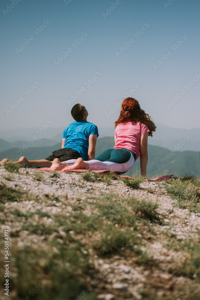 Yoga couple on the mountain streching