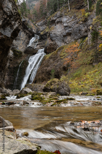 A waterfall in an autumn valley. Golden leaves and silky waters