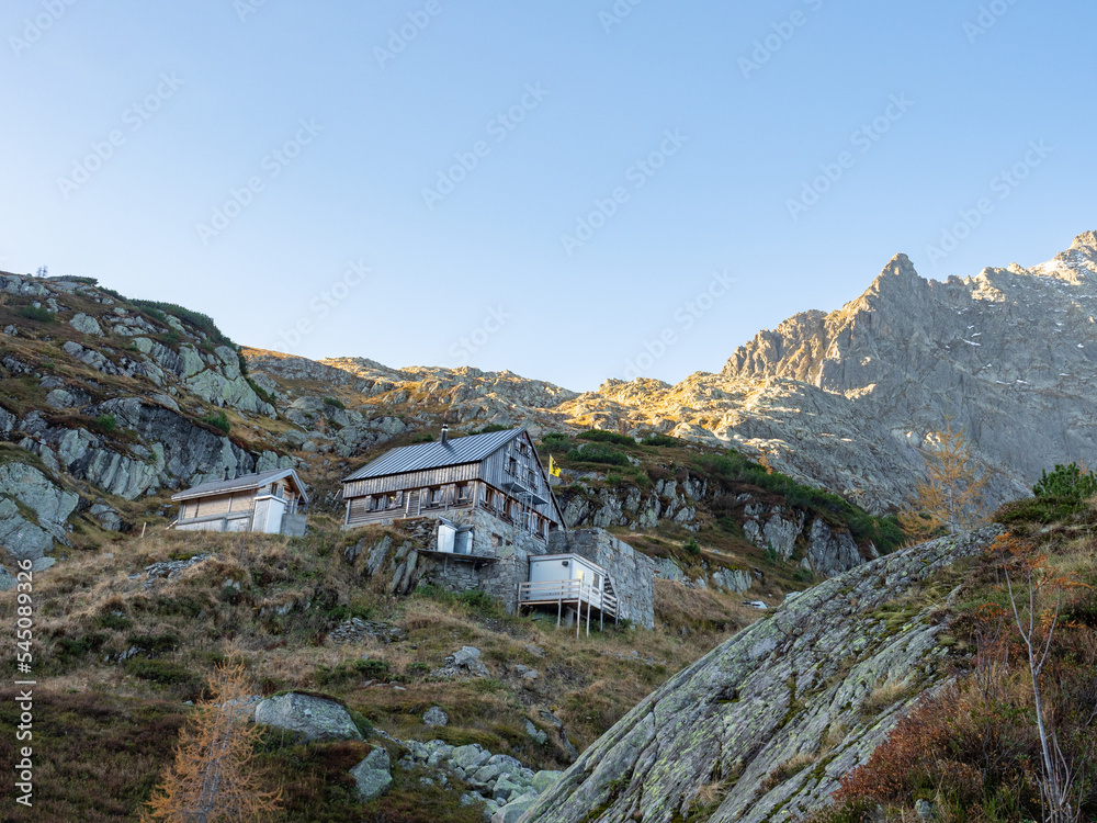 Windegg, Switzerland - October 17th 2022: A beautiful mountain hut in front of snow covered peaks