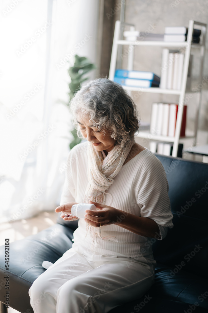 Old woman with bottle pills on hand going to take medicaments prescribed by his physician Old woman with bottle pills on hand going to take medicaments prescribed by his physician