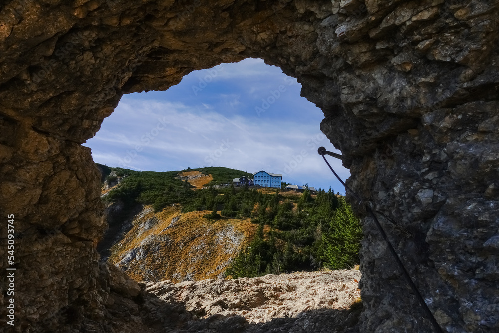 rocky round passage on a hiking path with view to a house