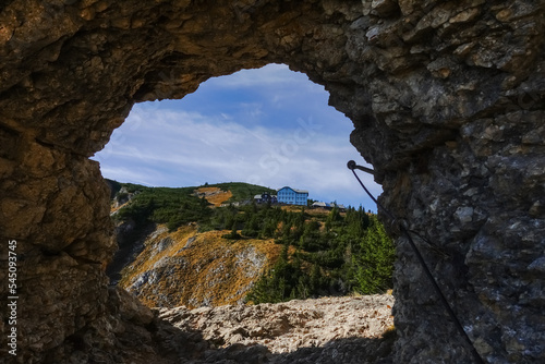 rocky round passage on a hiking path with view to a house