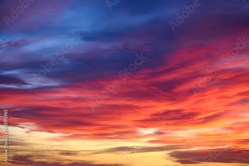 Sunset with sun and clouds on blue and orange dramatic sky. © GSDesign